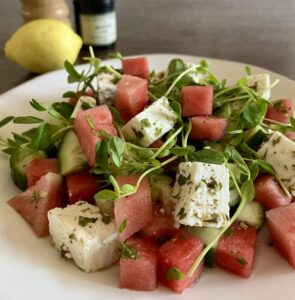 Watermelon and cucumber salad with marinated feta, Eatmore pea shoots, and fresh herbs.