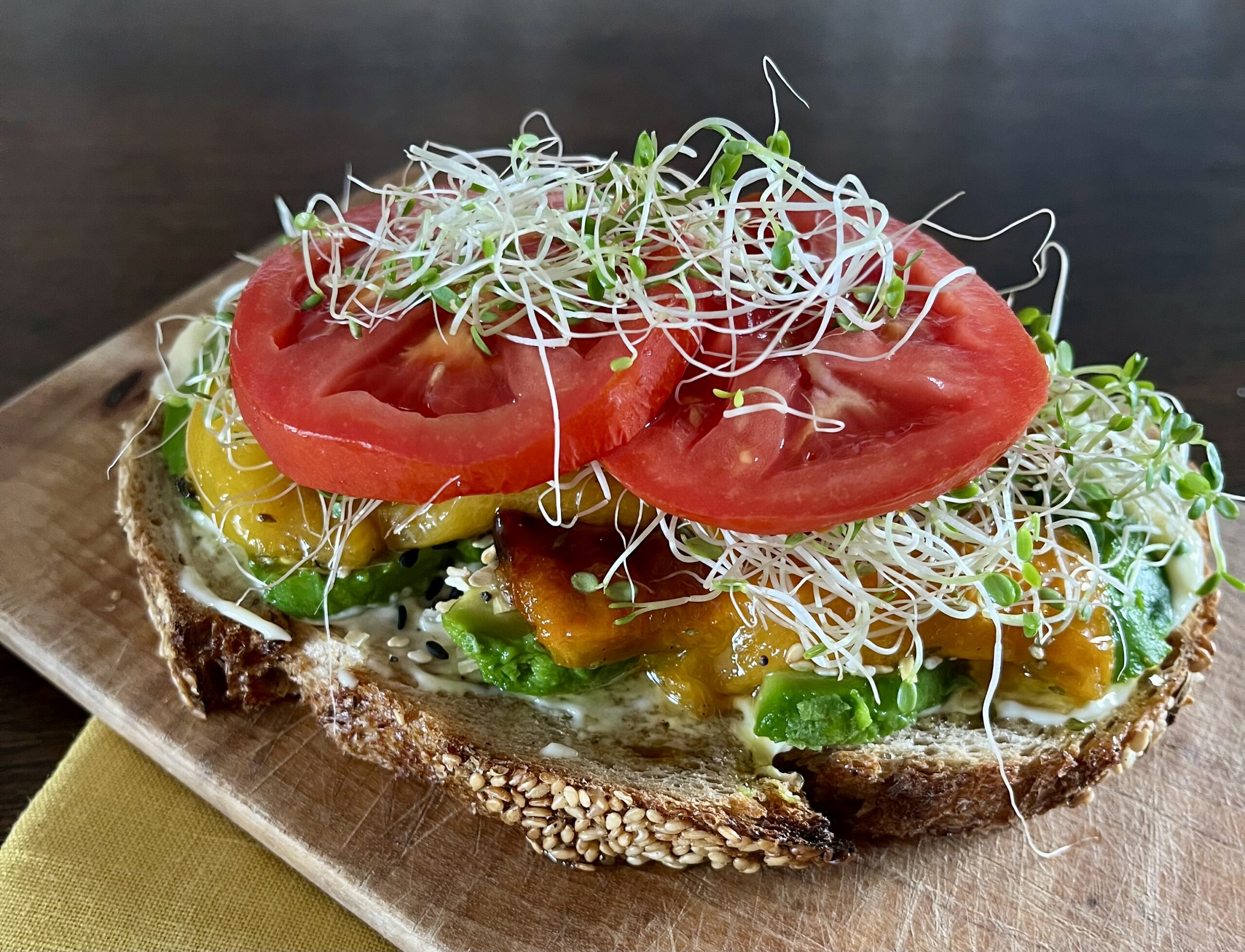 Sourdough sandwich with roasted marinated peppers, avocado, tomato and Eatmore Sprouts.